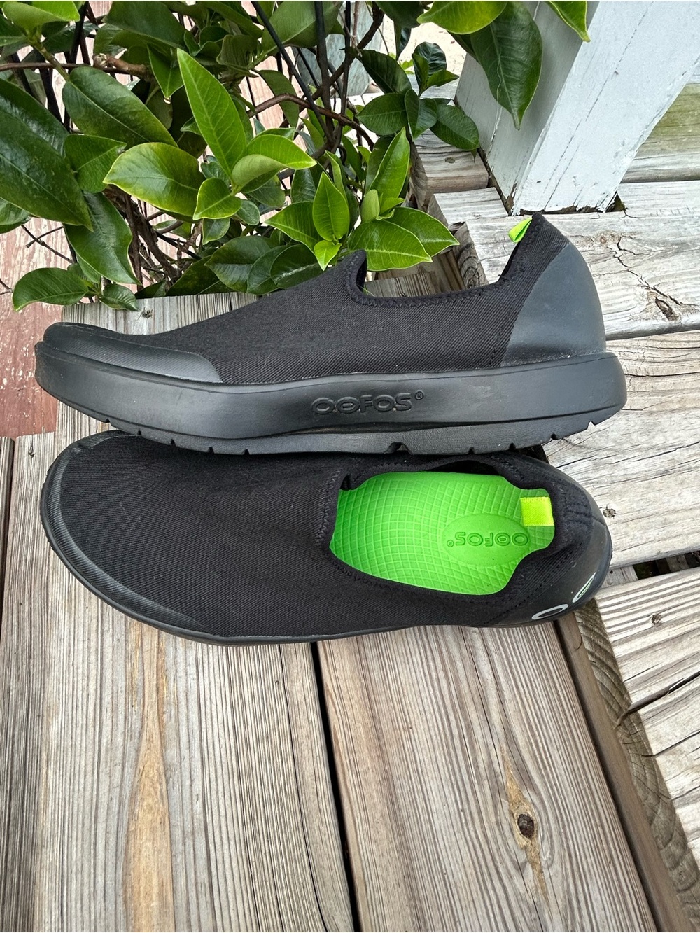 Oofos OOriginal women’s Slip-On Recovery Shoe in Black with Green Insole